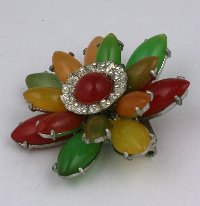 Unusual bakelite flower brooch from the late 1930's. Petals of marquise shaped bakelite in tones of tropical fruit set onto a metal base with pave rhinestone accents. Very dimensional and striking. 1930's USA. 2.5