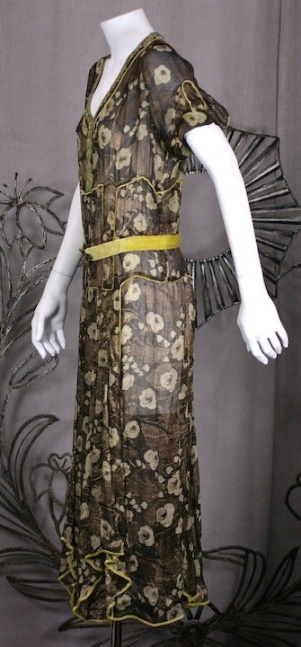 Unusual chiffon lame floral dress from the 1920's with chartreuse silk velvet piping and beadwork. Semisheer gown cut in alternating panels of  gold lame blooms which are accented by the acid velvet and matching beadwork down neckline. Silk