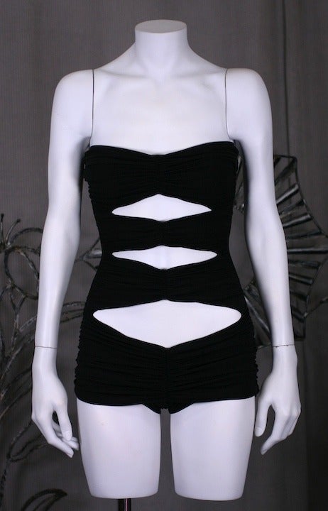 Original Norma Kamali Iconic draped swimsuit in black jersey  with 4 gathered sections across the front. The jersey is draped over a spandex base and the back is plain. 1940s retro styling with a sexy twist. 1980s USA. Made in Italy.
Size Vintage