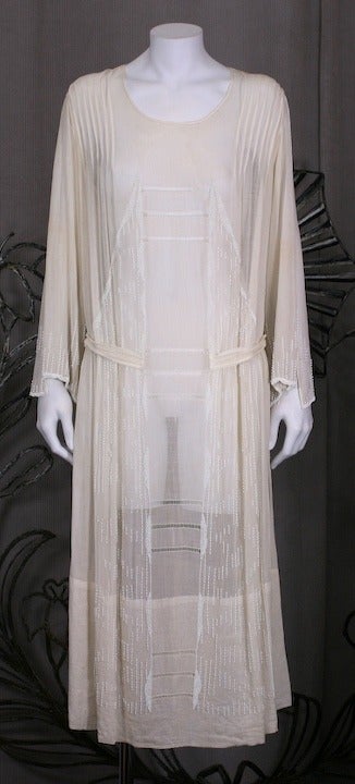 Rare soft ivory cotton voile beaded afternoon dress. Bodice has pin tucking and art deco chalk white bead embroidery. Slashed sleeves and half self belt and open work faggoting down center front. France 1920's. Excellent condition.

Bust 35