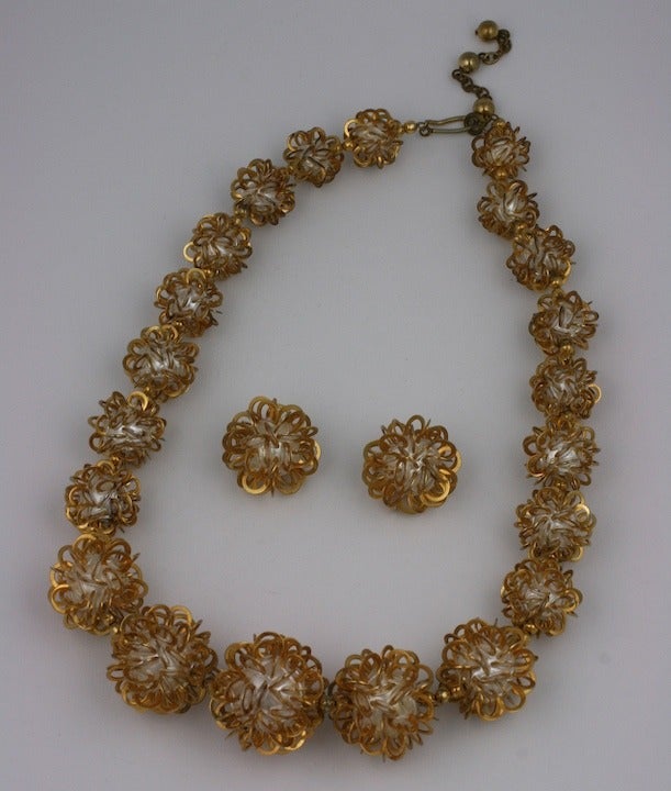 Ungewöhnliche, abgestufte Halskette und Ohrclips aus vergoldetem Metall mit flachen Ringen, eingebettet in barocke Perlen. Die Ohrringe sind mit Clipsor signiert, hergestellt in Frankreich.

Hals 20-22