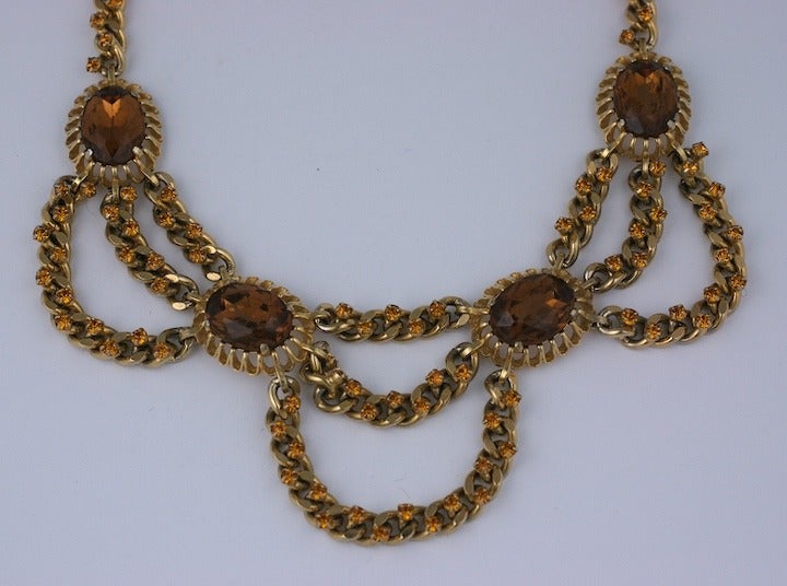 Schiaparelli gilt chain swag necklace studded with citrine crystals throughout. 4 central oval citrine pastes form the focus of this attractive necklace. USA 1950's, design France.
Extends from 14