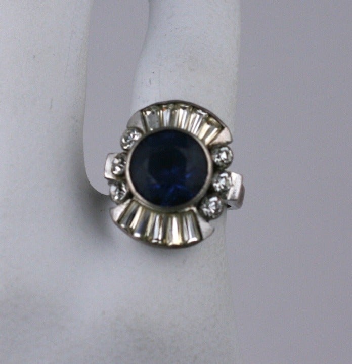 Striking cocktail ring with large deep blue paste surrounded by tapered baguettes and bezel set round pastes. Set in sterling silver. 1930's Germany.
Excellent condition.