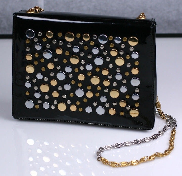 Studded mod bag from the 1960's on black patent leather. Studs are both silver and gold with a matching 2 toned shoulder chain. 
7