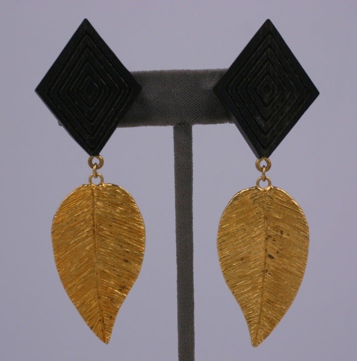 Yves Saint Laurent often combined organic elements into many of his jewelry designs and these are often the most interesting. Here a scored wood diamond is paired with a gilded etched leaf for rich contrast. 1980's France. Clip back fittings. 3.25