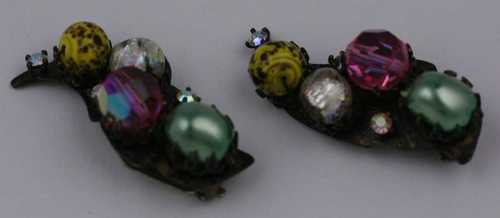 Earrings in these odd colorations could have only been made in Italy. Set on a dark bronze ground, there are celadon pearls, ruby cut crystals, iridiscent rhinestones, and chrome yellow speckled venetian glass beads. Unusual and charming. Clip back
