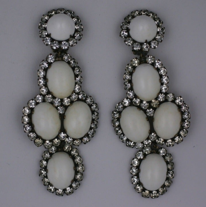 Large early Kenneth Jay Lane earrings of milk glass cabochons surrounded by pastes. Large and striking in scale. Clip back fittings.1960's USA. 4