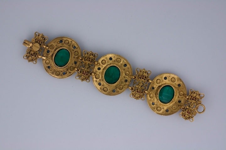 Imposing Chanel Haute Couture Byzantine link bracelet with poured glass cabochons of in emerald, ruby and sapphire. Ornate twisted wire decoration with etruscan work on gilt bronze. Early 1980's Haute Couture, Paris. Marked: Made in France. Length