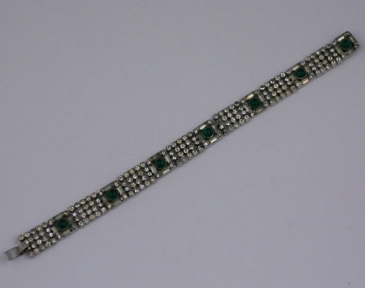 Elegant Art Deco bracelet of pave and baguette rhinestone stations with faux emerald cabochons. Beautiful quality with the look of real jewelry. High quality rhodium finish. 1930's USA. 7