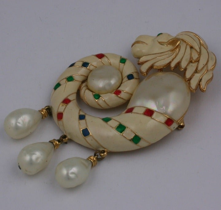 Hattie Carnegie Renaissance Revival Brooch of a large coiled lion surrounding a faux pearl button with pearl drops. This brooch is bold in scale and is enameled in cream with red, blue and green highlights.
American costume jewelry manufacturers