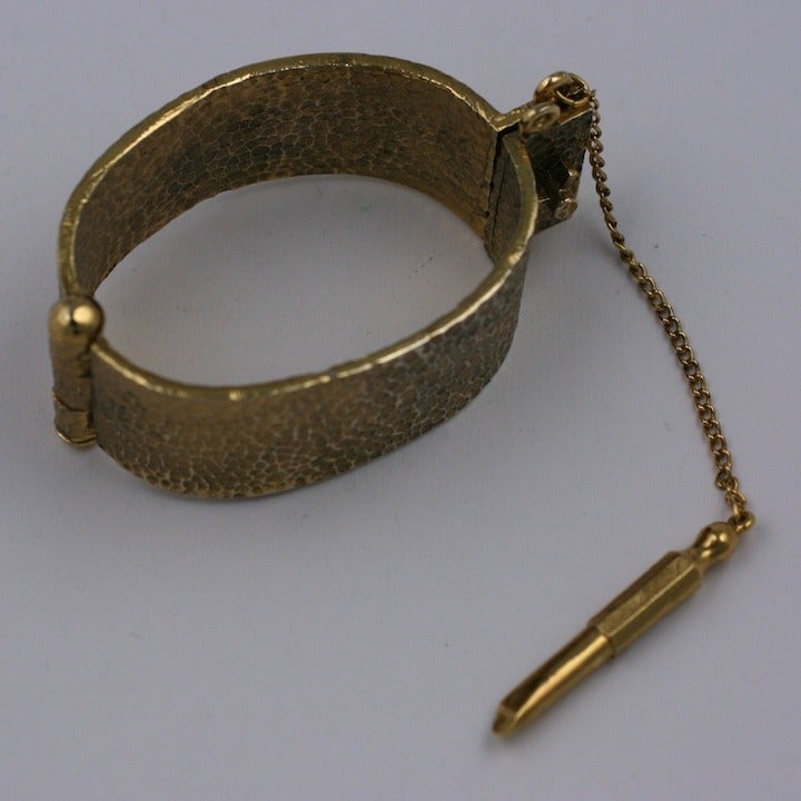 Unique novelty bracelet of hammered gilt metal with attached 