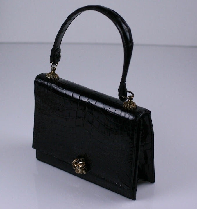 Elegant black alligator evening bag in diminutive size with jet paste detailing. The caps of the handle and the clasp are studded with jet rhinestones, Lined in calf leather. 1960's USA. Excellent condition. 7