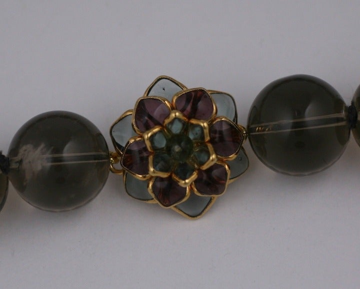 20 mm smokey quartz hand knotted beads with poured glass zinnia clasp in olivine and pale amythest. Hand made in our studios in France.
Length: 17.5