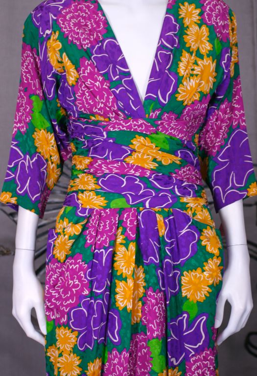 Sexy Louis Feraud draped midriff soft floral silk crepe day dress. Bright magenta, purple and mustard blooms on green grounds. 2 floating pockets from draped tucks at waist.<br />
Draped and tucked at bust as well. Bias drapee at midriff shapes