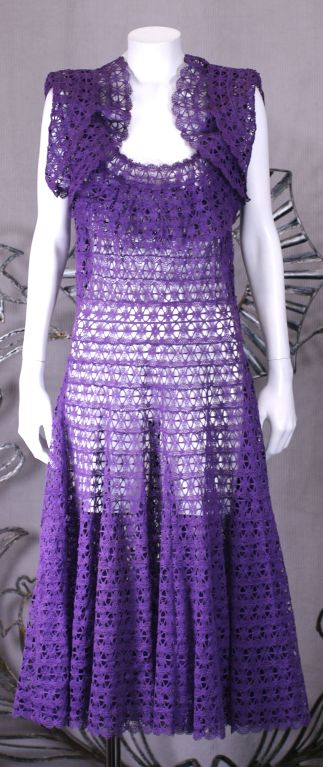 Charming 1950s dress made of purple cotton lace. The dress is composed of sewing lace tape concentrically to form the fabric. This forms a very full skirt without intricate seaming. The skirt is a full circle skirt and has great movement. There are