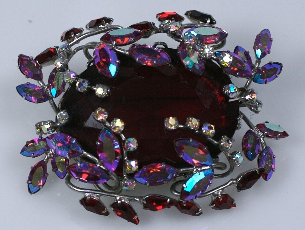 Unusual Czech brooch from the 1950s centering a large faux ruby with tendrils of ruby aurora and pave 