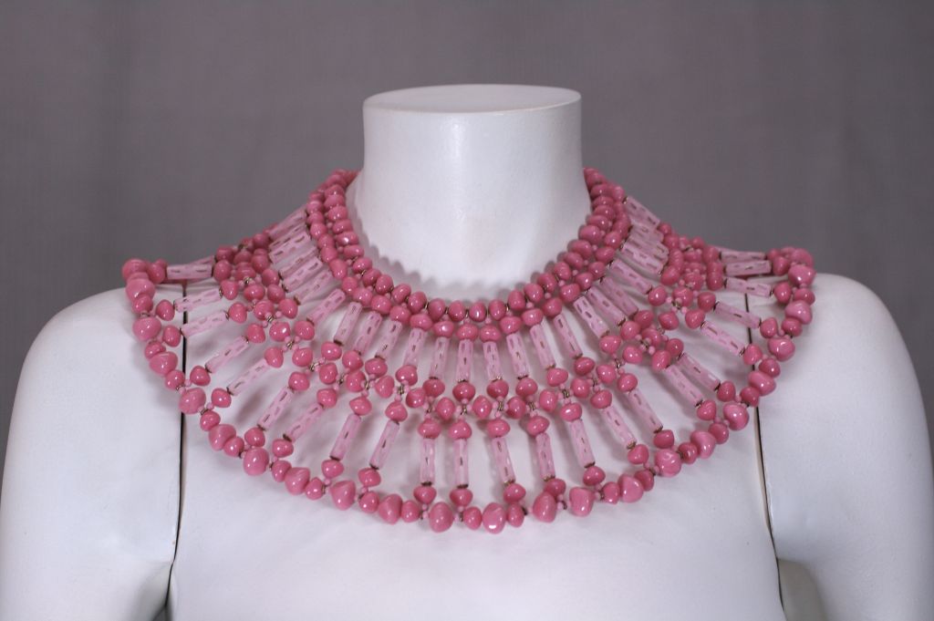 Exceptionnel plastron de Miriam Haskell des années 1960, composé de perles de résine laiteuse framboise mélangées à des barres gravées en pâte de verre. Grande échelle dramatique.<br />
Signé Miriam Haskell sur le fermoir en perles. <br />
16