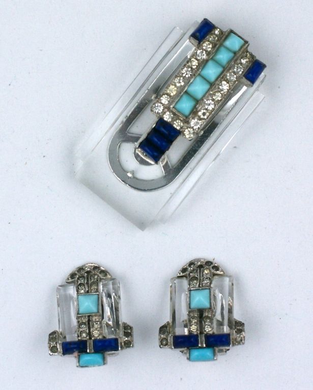 Rare and unusual dress clip and earrings from the 1930s. Alfred Philippe who originally designed for Cartier, Paris was head designer at Trifari when this suite was designed. Very Cartier and deco in feeling, the molded glass clip is set with buff