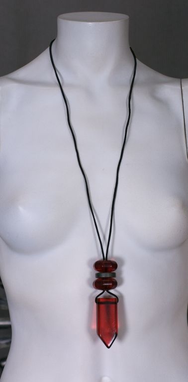 Collana francese in finto cristallo rosso sospesa a un cordoncino di cuoio, con due perle ottagonali rosse e una d'argento. Etichettato Made in France.<br />
Nuovo non indossato<br />
Corda 30