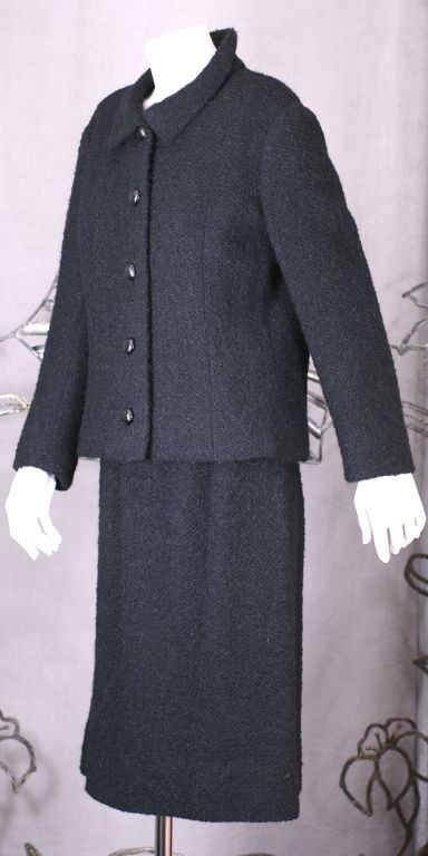 Impeccably tailored suit by Balenciaga/Eisa. Black wool boucle with fold over collar and large bombee black resin buttons. Simple tailored chic. Lined in silk crepe.<br />
Excellent condition.<br />
Skirt 30