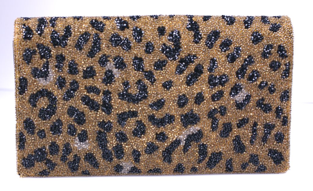 Clutch completely beaded with leopard spots circa 1980s. Intricately detailed with black faille lining and snap closure.<br />
5.5