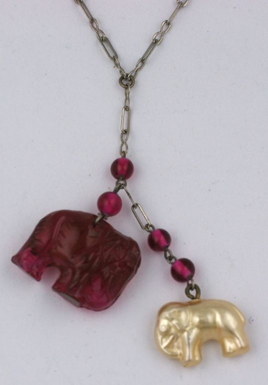 Collana francese Art déco con rubino e perle finte in pate de verre, progettata  con perline alternate di rubini e perle, che terminano con due ciondoli a forma di elefante in pate de verre.<br />
Condizioni eccellenti<br />
 Lunghezza 20