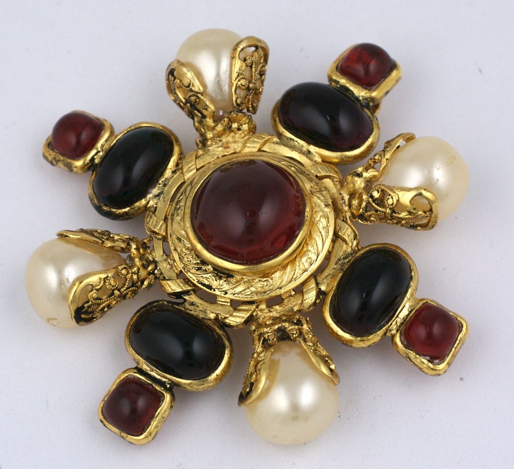 Iconic Chanel crest brooch from the 1980s of amythest and ruby poured glass enamel with a faux baroque pearl. <br />
Made in France by Maison Gripoix. Can also be worn as a pendant.<br />
Excellent condition<br />
3