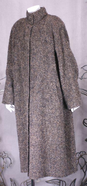 Full cut heathered boucle wool coat by Geoffrey Beene. Smock styling with band collar and gathered back yoke. Unusual 