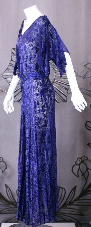 Wonderful quality floral cut silk chiffon velvet. 1930s evening dress of deepest purple with pointed hankerchief fluttering sleeves ,self belt, V neckline. Full flared skirt.<br />
length 55 in<br />
waist 34 in<br />
bust 40 in <br />
hip 40