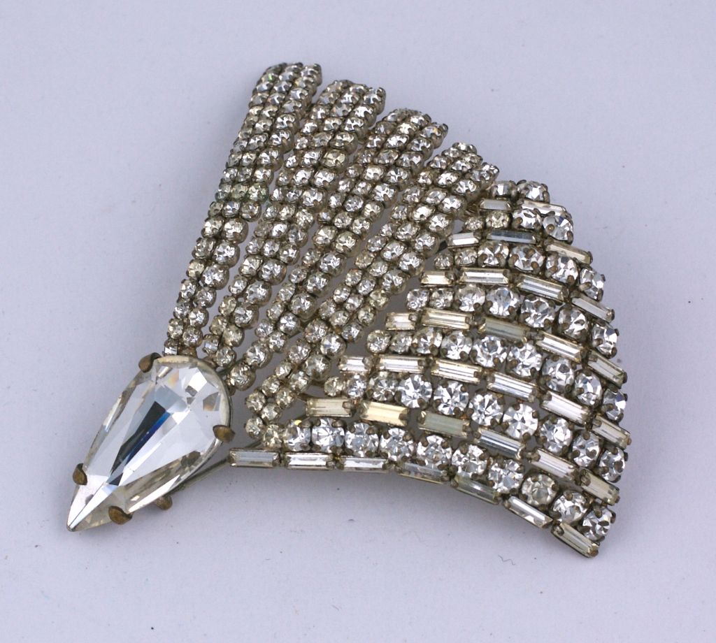 Intricate Swarovski crystal dress clip of baguettes, round and pear shaped stones. French manufacture from the late 1950's. Formed in a glamorous bombe fan shape and completely hand made. France 1950s.
Excellent condition.