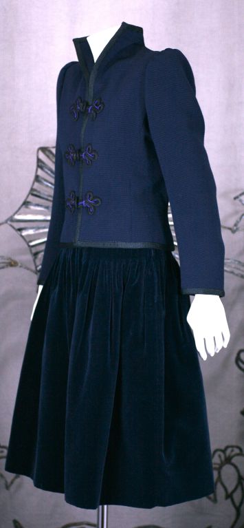 Haute Couture suit by Yves Saint Laurent from the Moroccan collection of the late 1970s (F/W 1979). The jacket,cut with signature strong shoulders is navy ottoman edged in black binding with purple and black hand made silk frogs. A gentle band