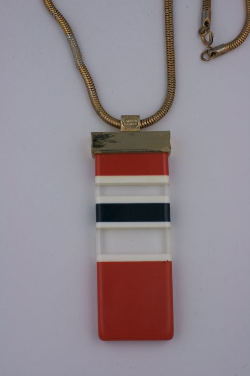 Large pendant by Lanvin circa 1970s in stripes of orange, white, black and clear resin. <br />
Gilt metal mount.<br />
Signed Lanvin<br />
Pendant 4 x 1.5"<br />
Chain 29"<br />
Excellent condition, tarnish to one inch of chain where