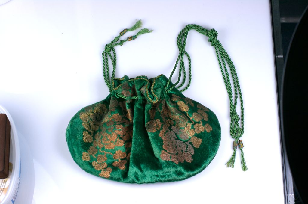 Evening bag of sea green silk velvet stenciled in a copper gold floral and leaf pattern , braided silk cords with venitian style glass trade beads.<br />
10