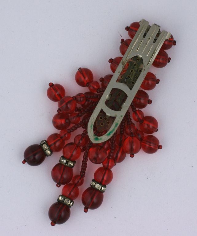 Early Miriam Haskell unsigned dress clip. Composed of varied ruby glass beads and rhinestone rondelles.<br />
<br />
4