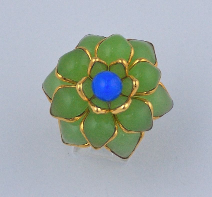 Handmade poured glass Zinnia ring made in French studios of Mark Walsh Leslie Chin. Lime chalcedony glass set within gilt metal. Blue chalcedony glass bead center. Dimensional ring with adjustable band. Made in France.
Images; Devon Aoiki in March