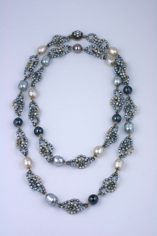 Miriam Haskell necklace composed of round interlocking pearl rings and variegated colored gray and white pearls,with faux hematite beads. Silver gilt metal and signature beaded clasp.<br />
Excellent condition