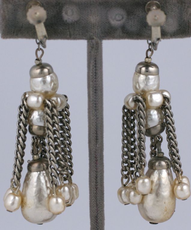 Boucle d'oreille longue à pompon Miriam Haskell, en chaîne de métal argenté et perles fausses larme et rondes.
Longueur 3 1/8