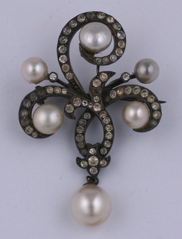 Edwardian paste brooch in the Romantic Style, of faux pearls and pastes set in sterling silver. Lone pearl dangles at base.<br />
excellent condition circa 1900.
