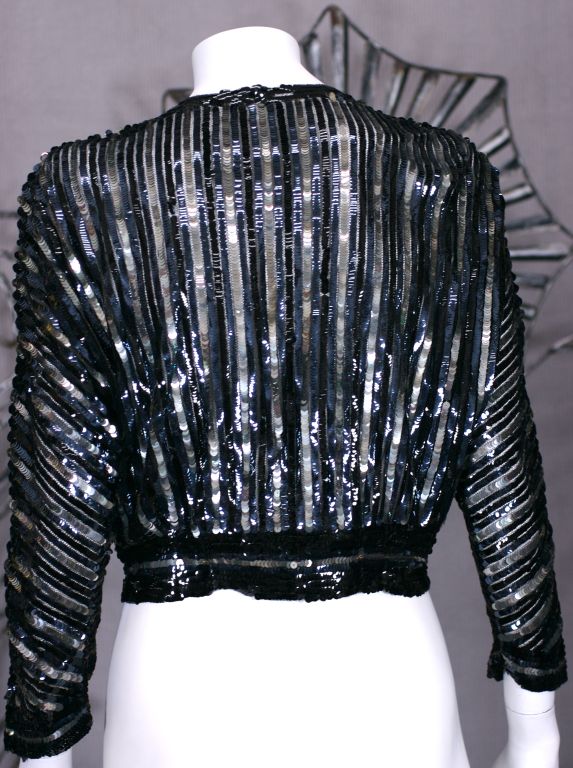 Deep navy, jet and silvered sequin striped evening jacket on silk tulle base from the 1930s. Hook and eye closure at neck and waist. X-Small size, France 1930s.
Excellent condition. Length 16