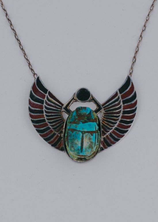 Egyptian revival art deco scarab necklace in sterling silver with black and red enamel. A faience scarab set between the enameled wings. Necklace back stamped 925. 1930s European<br />
Excellent condition