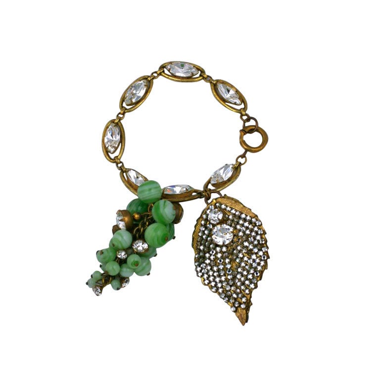 Miriam Haskell green faux jade Grape Cluster fob bracelet
c. 1950 designed by Frank Hess.

A Cluster of Pate de Verre Beads and Prong-set rhinestones with a Rose Montee Pave leaf suspended from a Gilded Metal and Marquise Crystal Bracelet.
3.5
