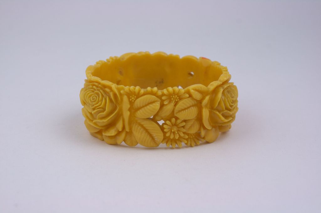 Molded celluloid wide bangle from the 1930s. 3 large high relief rose motifs with leaves cover the entire bangle.<br />
Excellent condition. Circa 1930s.<br />
1.25