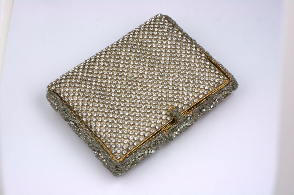 Unusual clutch purse with minaudiere fittings for powder, lipstick and mirror. There us also an additional satin pocket in the interior.<br />
Beautifully crafted in France of satin overlaid with bezel set crystals on both sides. The frame is