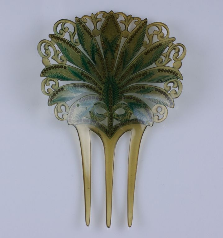 Large faux horn celluloid hair comb from the early part of the 20th Century. Patinaed with green leaves and accented with blue rhinestones throughout the leaves.<br />
Excellent condition.