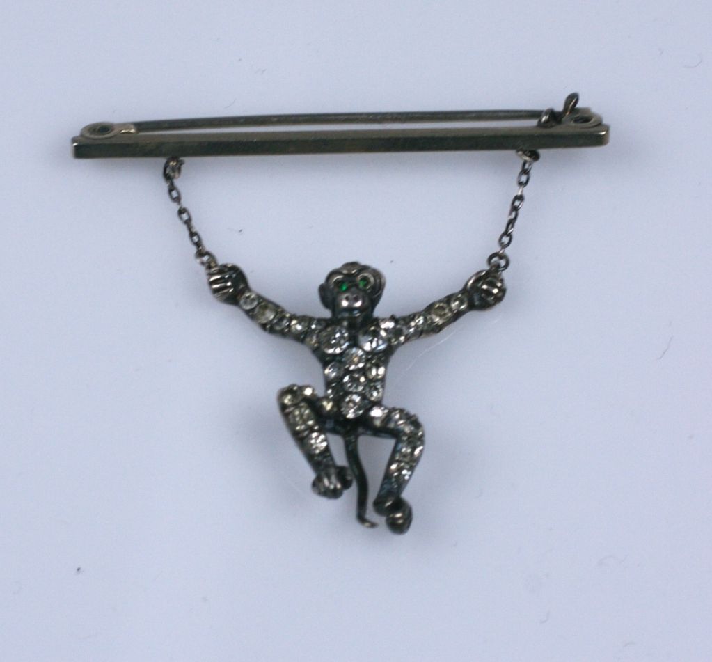 Charming paste set monkey dangling from a bar. Completely set in sterling with handmounted pastes circa 1880s. Unusual novelty piece from the Victorian era.<br />
Excellent condition.