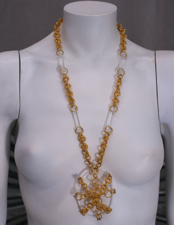 Cool lucite and gilt chain pendant from the 1960s. Chunky ribbed links are wrapped around the lucite oval and lucite stations are spaced into the neck chaining.<br />
Excllent condition<br />
Pendant 3.5