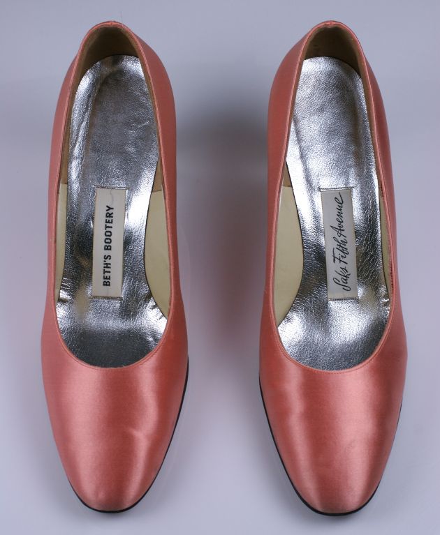 Elegant Beth's Bootery Lucite Heel Satin Pump. Pale Pink silk satin with mod 2.25" heel in lucite. 
Silver lined.  Size 7B Vintage. 1960's USA.
Excellent condition. 
Length 9.25", Width widest on sole 3", Widest across top of foot