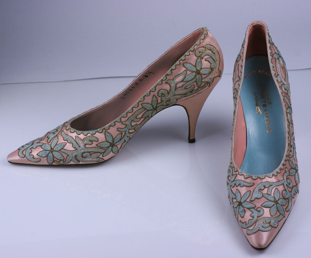 Description: Chic, elegant pumps from the 1950s Italy. Lovely tambour embroidery in blue and gold on a pink satin ground.<br />
Retailed by Saks Fifth Ave.<br />
Marked 6B on sole and 6 1/2 inside shoe, vintage sizing<br />
Excellent condition.