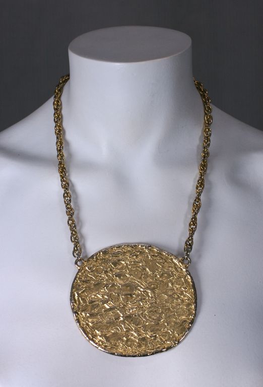 Large gold disc pendant in with molten, hammered finish. Simple and striking, perfect with a summer tunic.<br />
Excellent condition