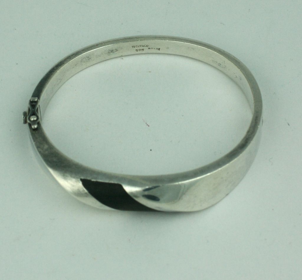 Unisex sterling silver bangle inlaid with  a swirl of ebony circa 1970s. Side clasp closure,suitable for both men and women.
Excellent condition<br />
interior diameter 2.25